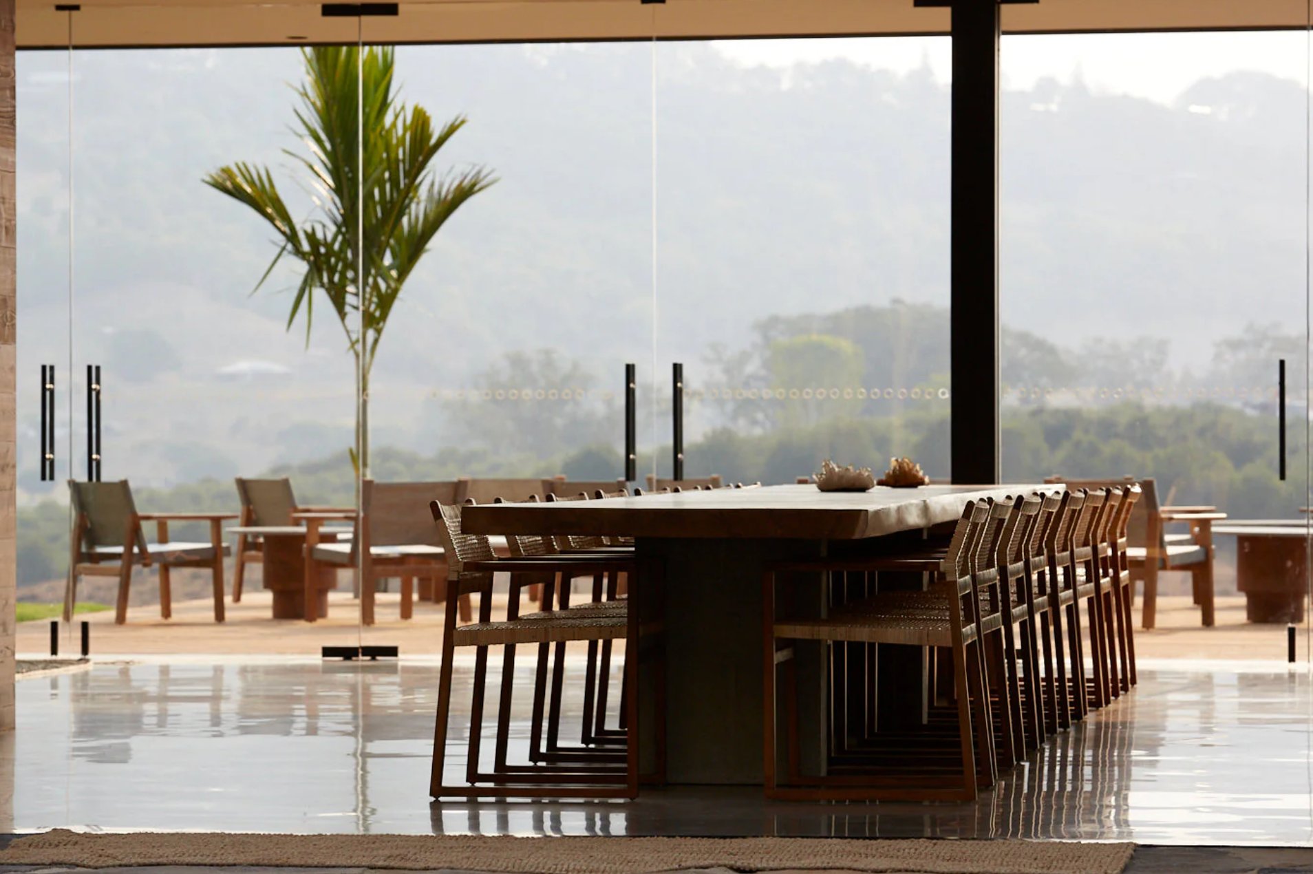The long dining table at SOMA, with hinterland views through floor-to-ceiling glass